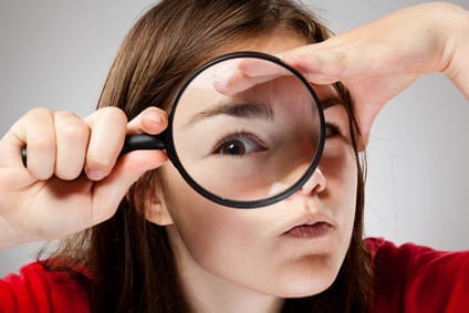 girl holding magnifying glass